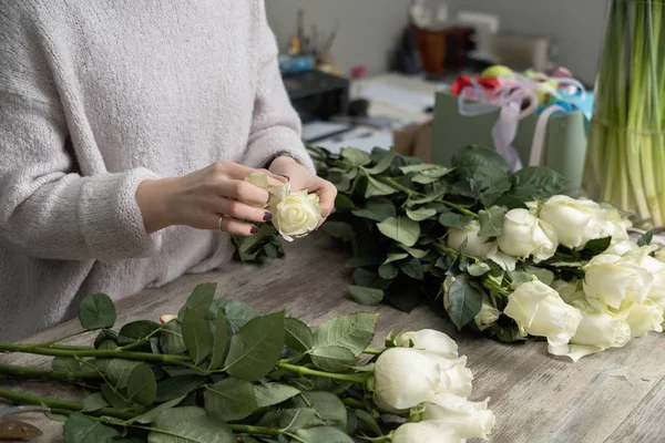 Florist with bouquet of roses at work.