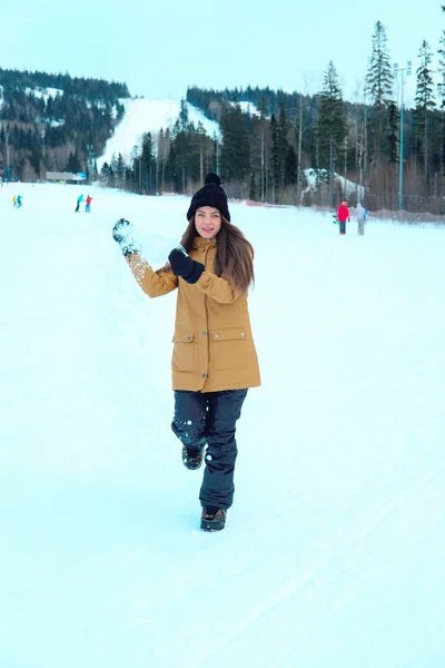 Linda chica con una tabla de snowboard en la estación de esquí —  Fotos de Stock