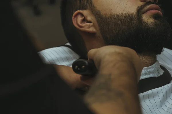Detalhes de aparar. Barbear uma barba a um cliente numa barbearia — Fotografia de Stock
