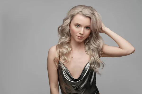 Fashion portrait of a  young woman in a sexy silver top with a n — Stock Photo, Image