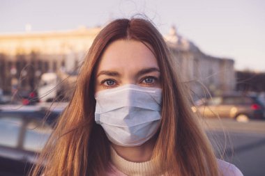 SARS-CoV-2 virüsünü yaymak için maske takan şehir sokaklarındaki COVID-19 pandemik Coronavirus kadını. Coronavirus Hastalığı 2019 'a karşı cerrahi maskeli bir kız..