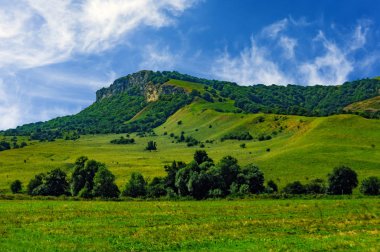 Yeşil çim Hill ve bulutlu gökyüzü