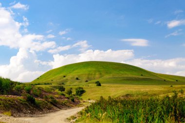 Yeşil çim Hill ve mavi gökyüzü