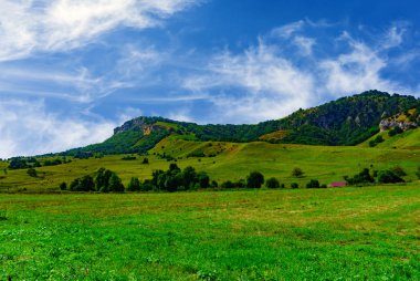 yeşil tepeler ve mavi gökyüzü bulutlu