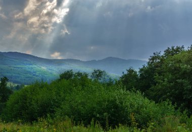 Güneş ışınları yeşil dağların üzerinden