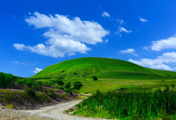 Yeşil çim Hill ve mavi gökyüzü