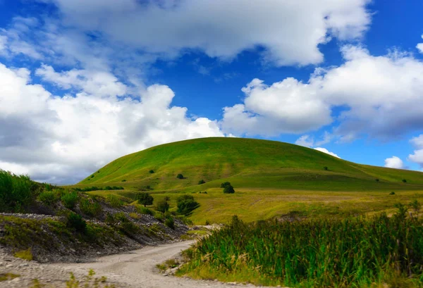 Yeşil çim Hill ve mavi gökyüzü