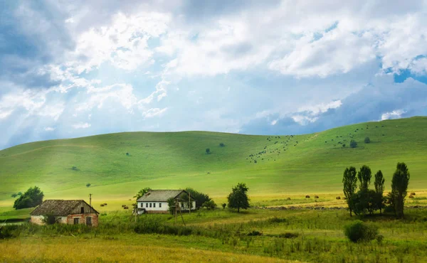 Yeşil tepelerin eteklerinde, büyük çiftlik — Stok fotoğraf