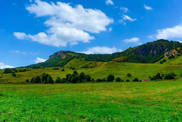 Grüne Hügel und blauer Himmel mit Wolken — Stockfoto