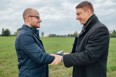 İki genç yatırımcı bir iş toplantısı yapıyor ve bir h veriyor
