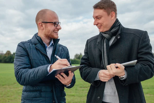 Двоє молодих інвесторів проводять ділову зустріч і сміються — стокове фото