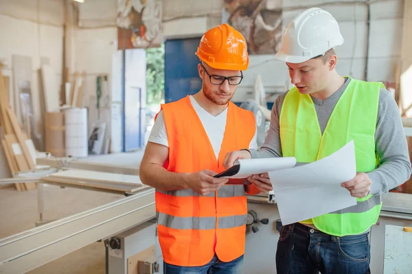 Zimmerleute analysieren Baupläne — Stockfoto