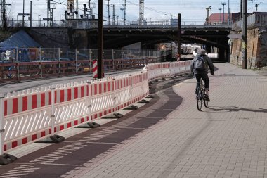 Cyclists at a construction site barrier at the construction site of the City Tunnel in Magdeburg clipart