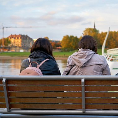     Anne ve kızı Dresden Elbe kıyısındaki bir bankta oturup                           