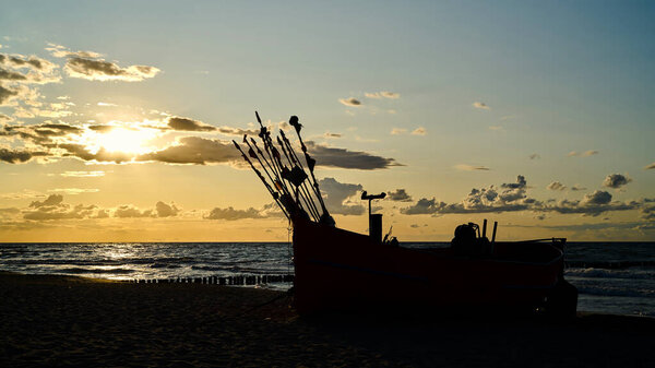  Fishing boat at sunset on the beach of the Baltic Sea near Rewal in Poland                              