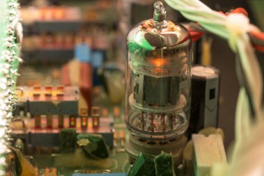 Elektrik devresi, elektrik bileşenleri ve kabloları olan bir devre kartında parlayan bir tüp.
