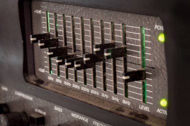 Bir gitar amplifikatöründen gelen ses eşitleyicisinin eski siyah tozlu kontrolleri