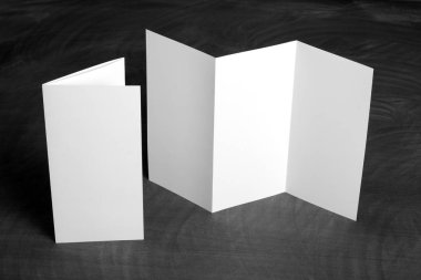 Boş beyaz kağıt el ilanı siyah bir kara tahta katlama