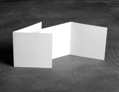 Boş beyaz kağıt el ilanı siyah bir kara tahta katlama