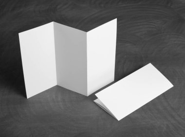 Boş beyaz kağıt el ilanı siyah bir kara tahta katlama