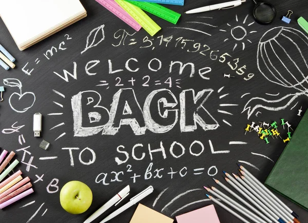 "Retour à l "école" écrit à la main avec des fournitures scolaires sur un bac noir — Photo