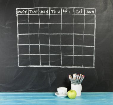 Grid timetable schedule on black chalkboard background. clipart