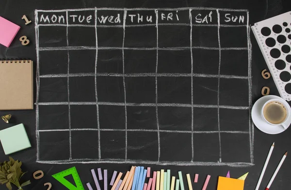 Calendário de grade com papelaria em chalkboard preto de volta — Fotografia de Stock