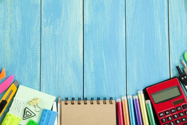 Okul malzemeleri mavi ahşap arka plan üzerinde