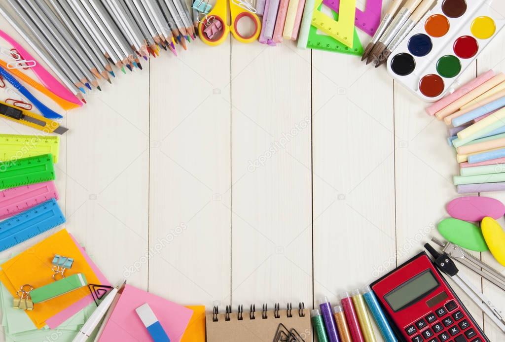 School supplies frame on a wooden background.