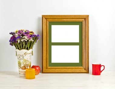 Kahverengi kare mockup alan çiçek vazo, elma, kupa ve mum ile. Boş çerçeve tanıtım tasarım için sahte. Modern sanat için şablon çerçeveleme