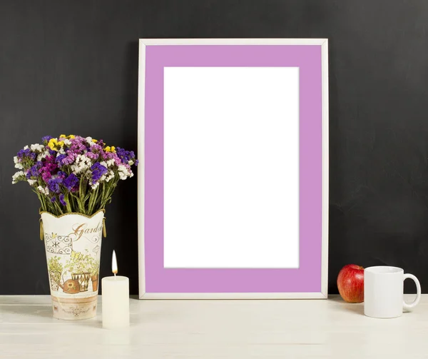 Fame mockup with field flowers in vase, apple, mug and candle. Empty frame mock up for presentation design. Template framing for modern art