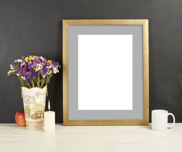 Brown frame mockup with field flowers in vase, apple, mug and candle