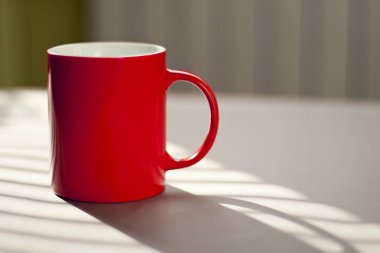 Bir tablo odaklanmamış arka plan üzerinde kırmızı kupa duran.