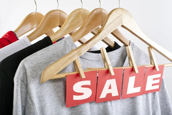 Sale in a clothing store - discount sign at a clothes rack. — Stock Photo, Image