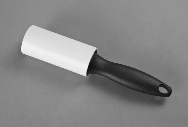 Cepillo de rodillo de lana limpia con mango negro sobre fondo gris . — Foto de Stock