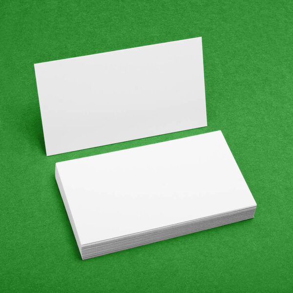 Blank business cards on green background