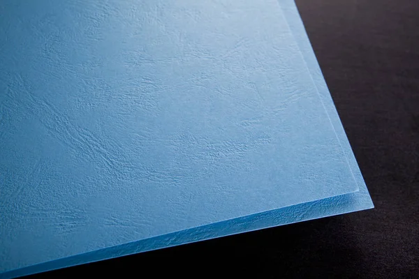 Stočený roh modrého papíru. Vysmívat se. Zblízka. Makro snímek. — Stock fotografie
