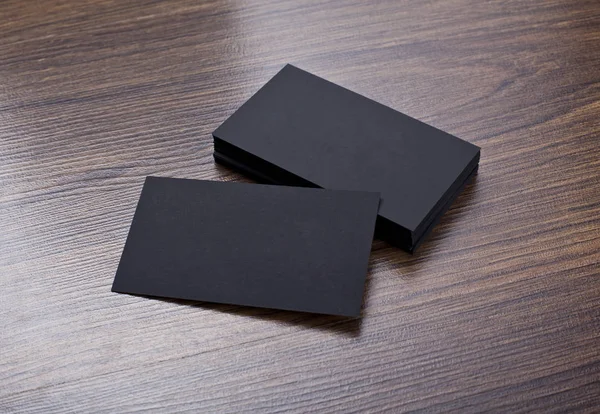 Mockup of black business cards at wooden background
