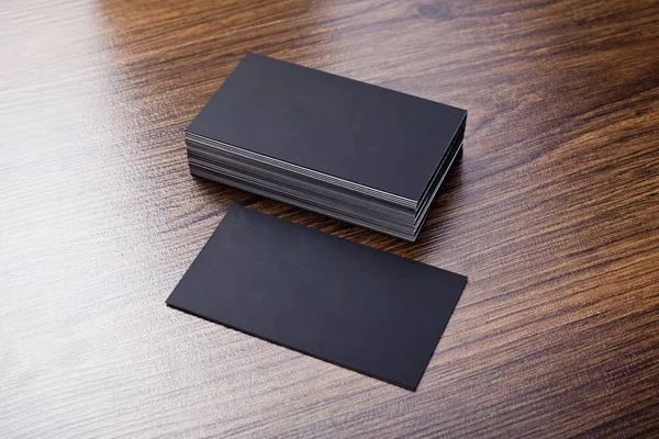 Mockup of black business cards at wooden background