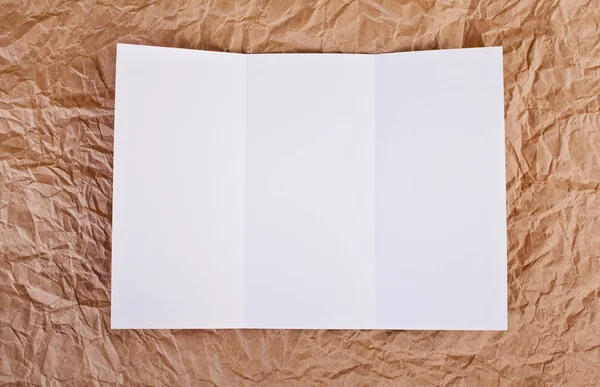 Üres ablak fold szórólap a barna ráncos papír háttér. — Stock Fotó