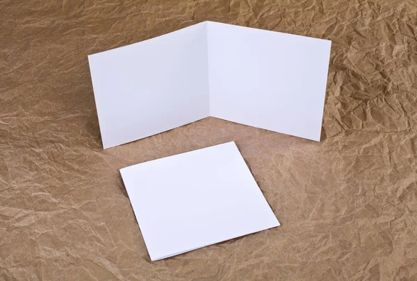 Blank white greeting card at a wrinkled paper background — Stock Photo, Image