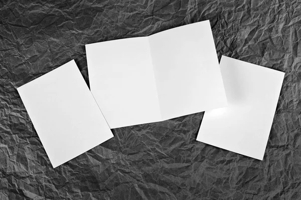 Leere weiße Grußkarte vor faltigem Papierhintergrund — Stockfoto
