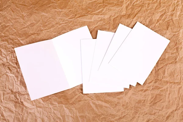 Leere weiße Grußkarte vor faltigem Papierhintergrund — Stockfoto
