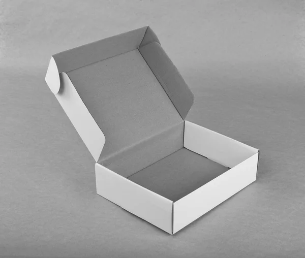 Opened white cardboard box for packaging on a gray background. — Stock Photo, Image