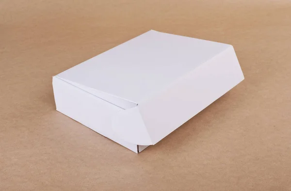 Closed white cardboard box for packaging on a beige background. — Stock Photo, Image