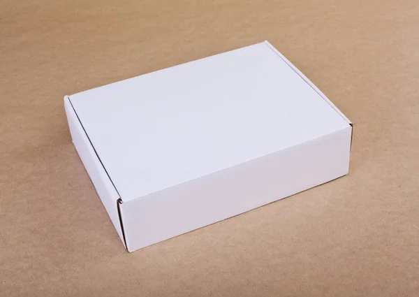Closed white cardboard box for packaging on a beige background. — Stock Photo, Image