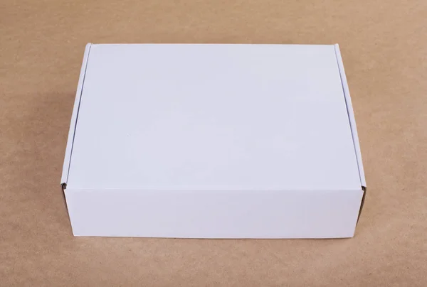 Closed white cardboard box for packaging on a beige background. — Stock Photo, Image