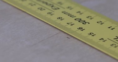 Tahta bir yüzeye cetvel ve kalemle düz bir çizgi çiziyorum.