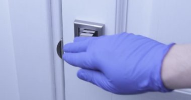 Coronavirus COVID-19 Önleme temizlik görevlisi antibakteriyel dezenfekte beziyle kapı tokmağını temizliyor.