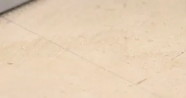 Tahtayı büyük dairesel bir testere ile kesen bir marangoz.